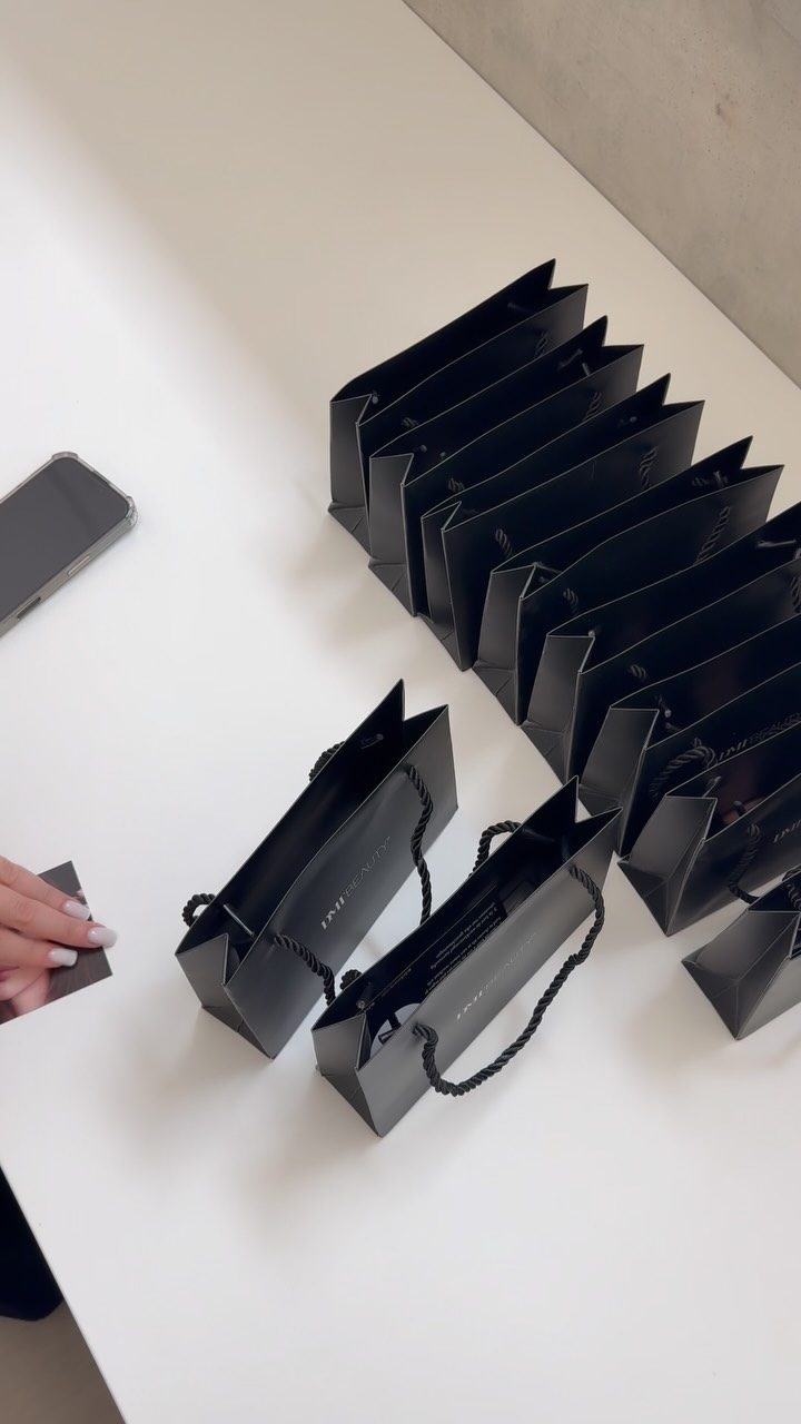 Zwarte tasjes met hun eigen browgel op een witte tafel